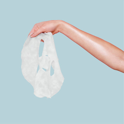 Hand holding a white fabric against a light blue background