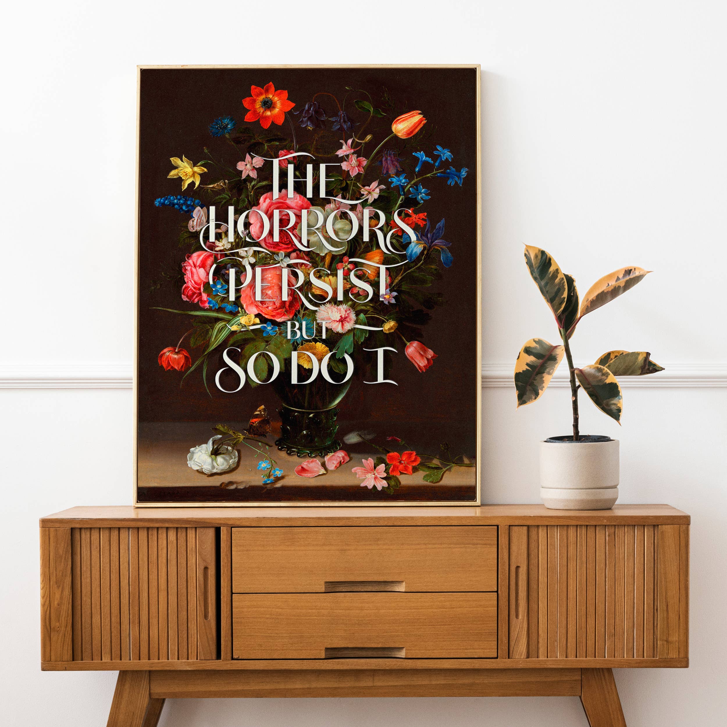 Decorative poster with floral design and text on a wooden cabinet against a white wall.