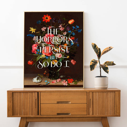 Decorative poster with floral design and text on a wooden cabinet against a white wall.