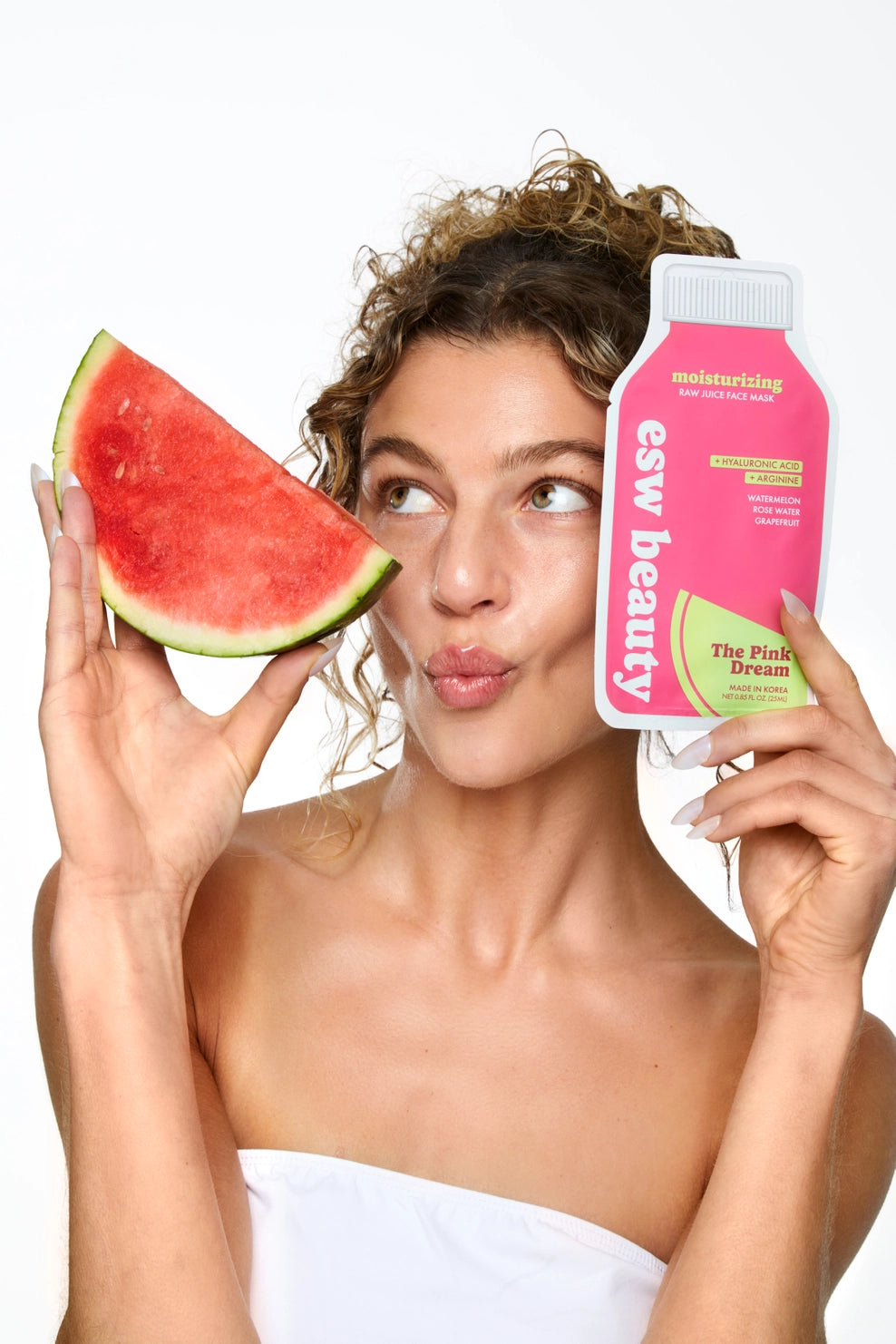 Woman holding a watermelon slice and a pink skincare product with 'esw beauty' branding.