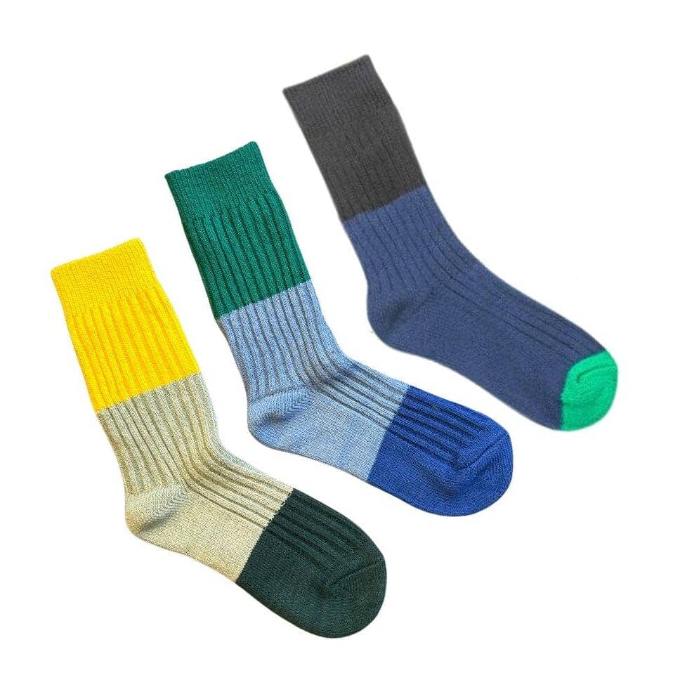 Three pairs of color-blocked ribbed crew socks arranged diagonally on a white background. The left sock is yellow, beige, and dark green.