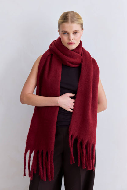 Woman wearing a red scarf against a white background