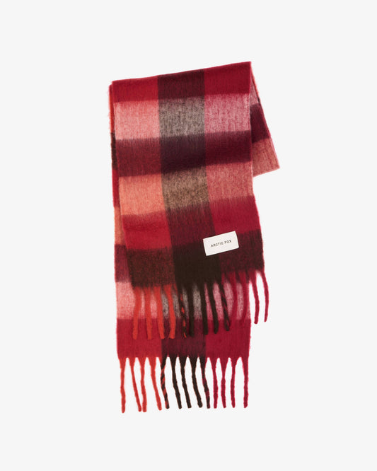 A folded plaid scarf in shades of red, pink, and dark brown, featuring a small white brand tag and fringed ends, set against a plain white background.