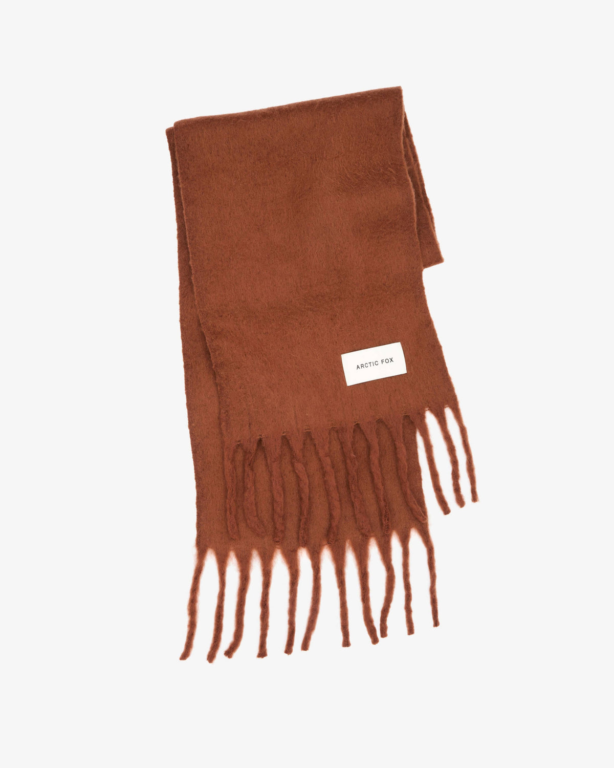 A rust-brown knit scarf with fringed ends and a small white rectangular brand label, photographed on a clean white background.