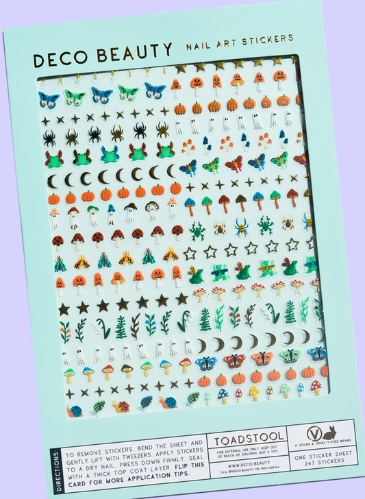 A sheet of Deco Beauty nail art stickers by Toadstool, featuring a variety of autumn and nature-themed designs like pumpkins, mushrooms, trees, stars, and moons on a mint green backing card.