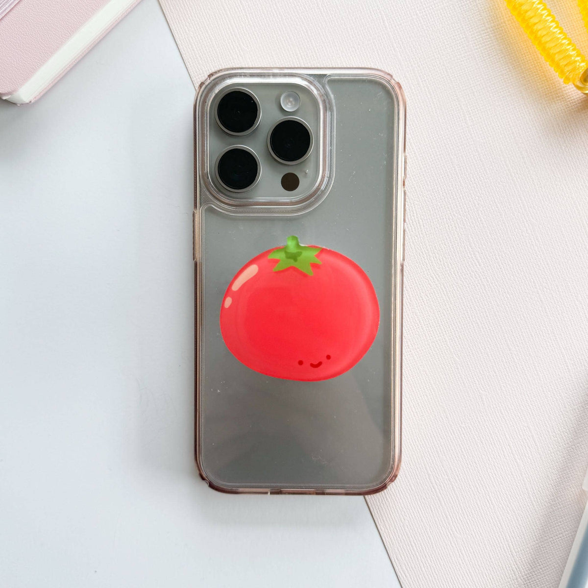 Phone case with a tomato design on a light surface