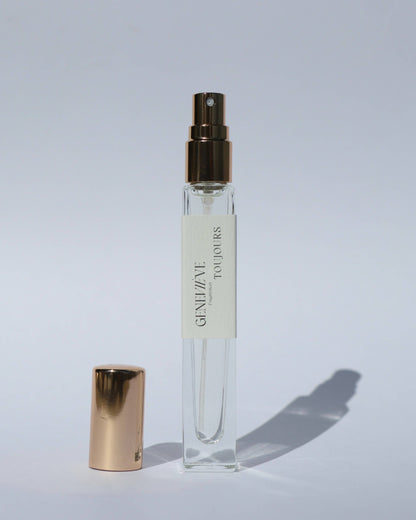 Small spray bottle with gold cap and visible brand name on a light gray background