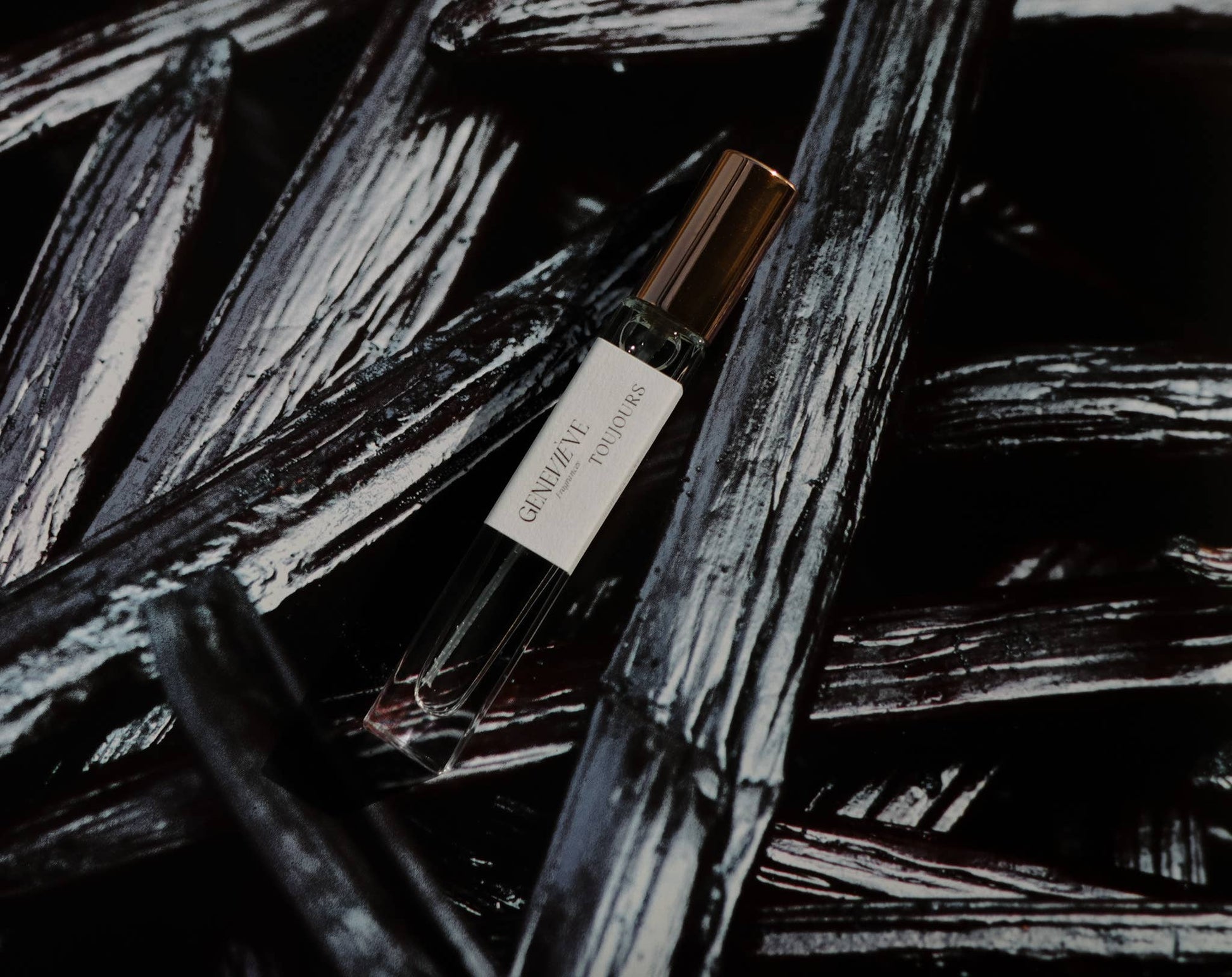 Perfume bottle on vanilla beans with a dark background