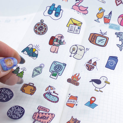 Sheet of colorful travel-themed stickers with a hand holding a sticker.