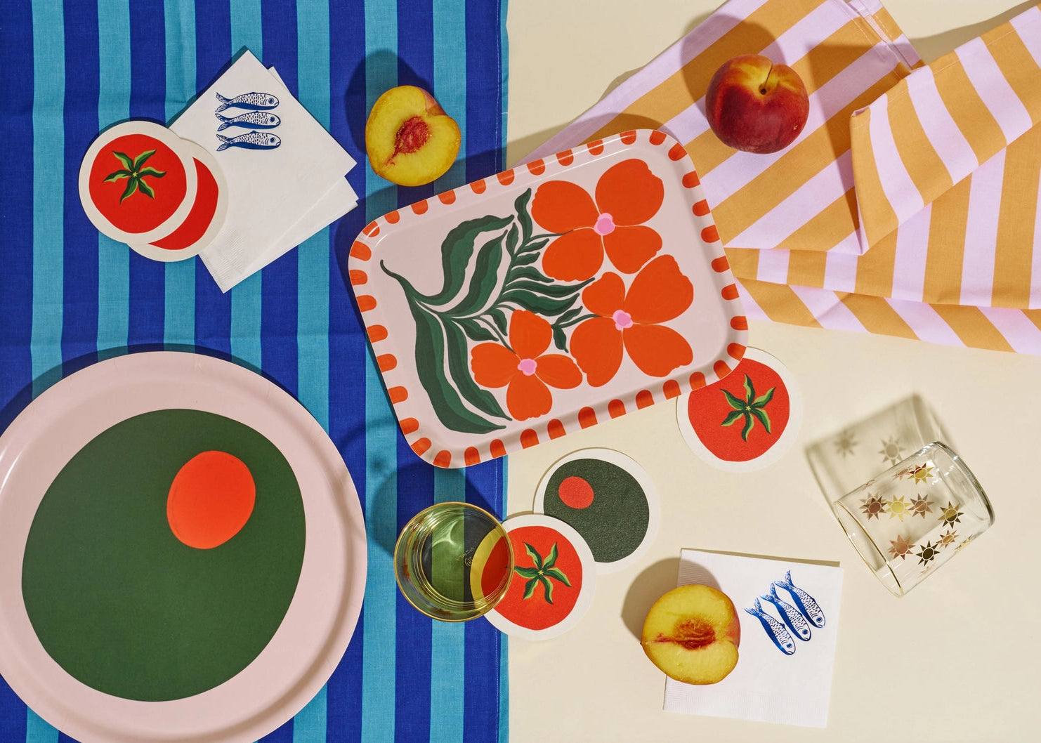 Colorful table setting with a floral placemat, striped cloth, and decorative items.