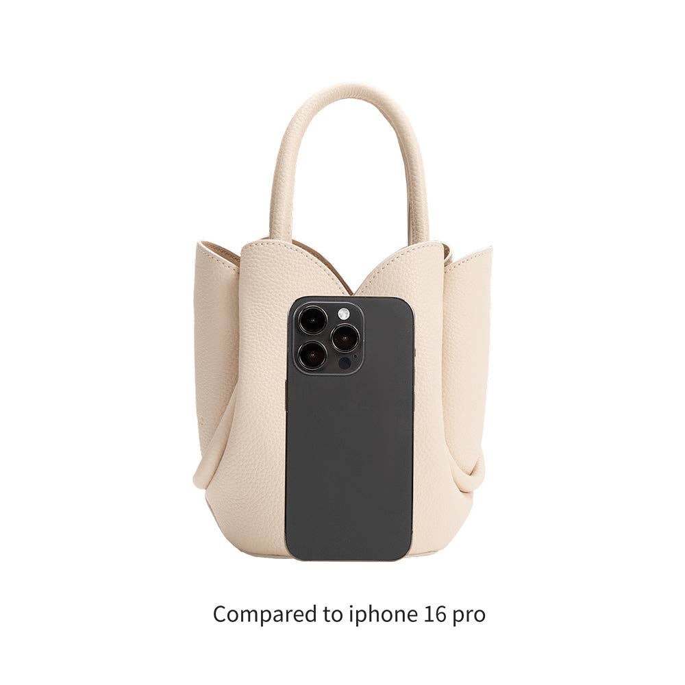 Beige handbag with a black phone case inside, compared to iPhone 16 Pro on a white background