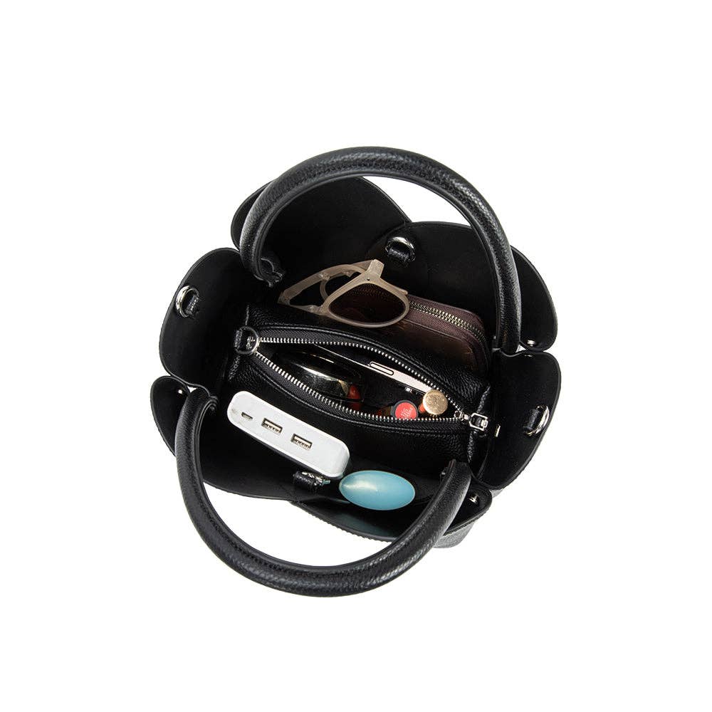 Black handbag with a mirror and various items on a white background