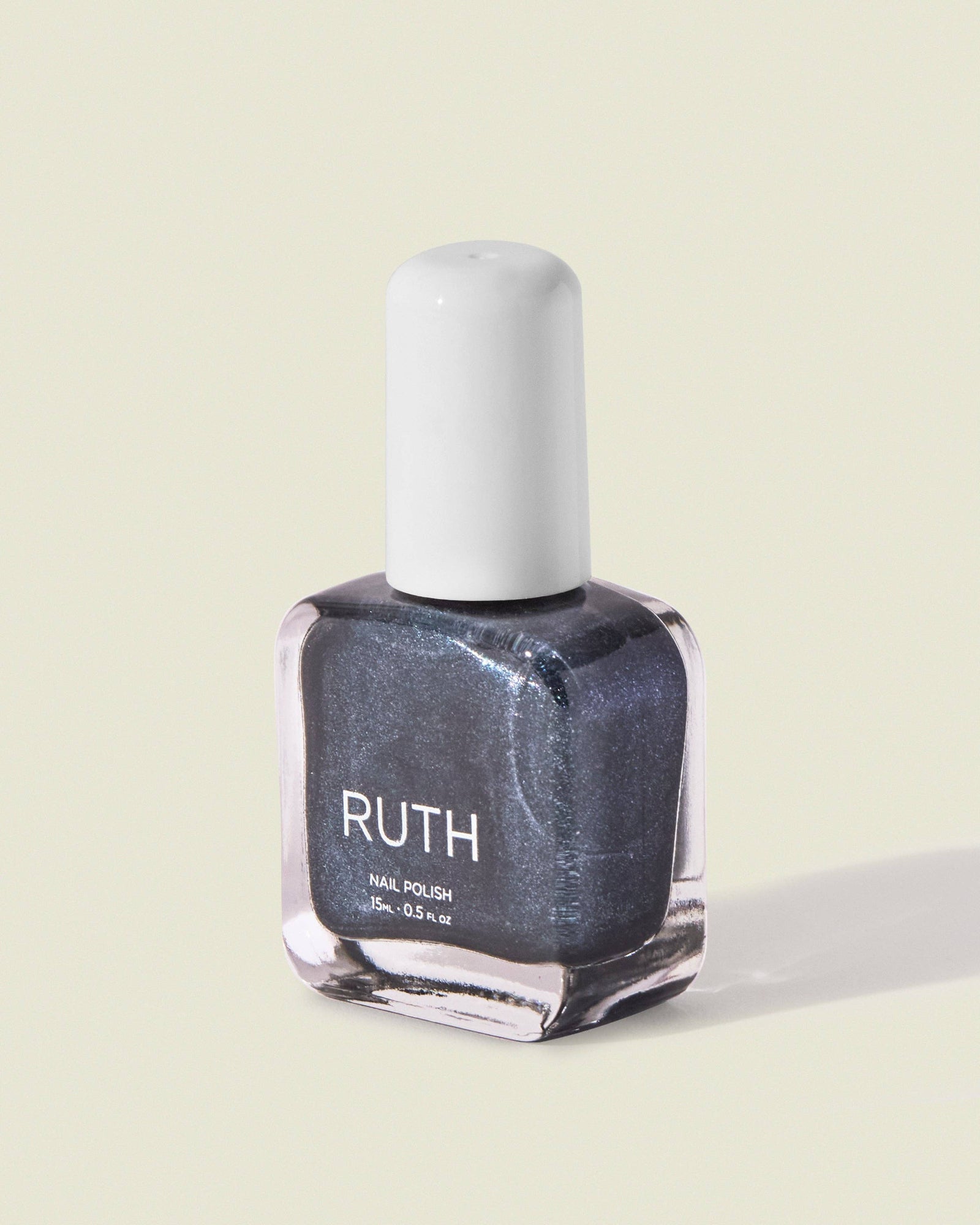 Nail polish bottle labeled 'RUTH' on a light green background, Twilight Metallic Grey Nail Polish