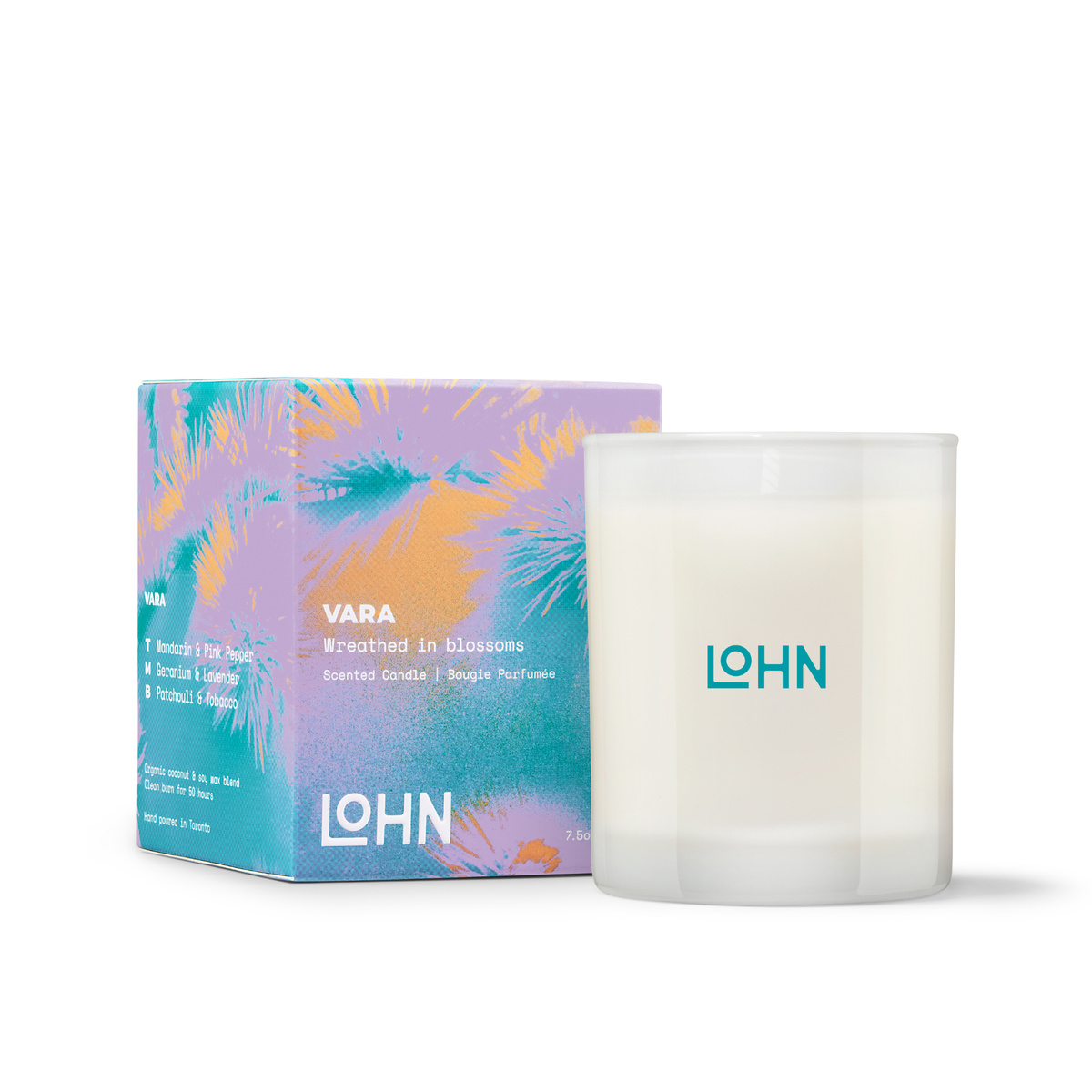 A white glass jar candle with a frosted lid and teal LOHN branding, shown next to its colorful product box featuring purple, teal, and orange tropical leaf patterns. The box is labeled 'VARA' and 'Wreathed in blossoms'.