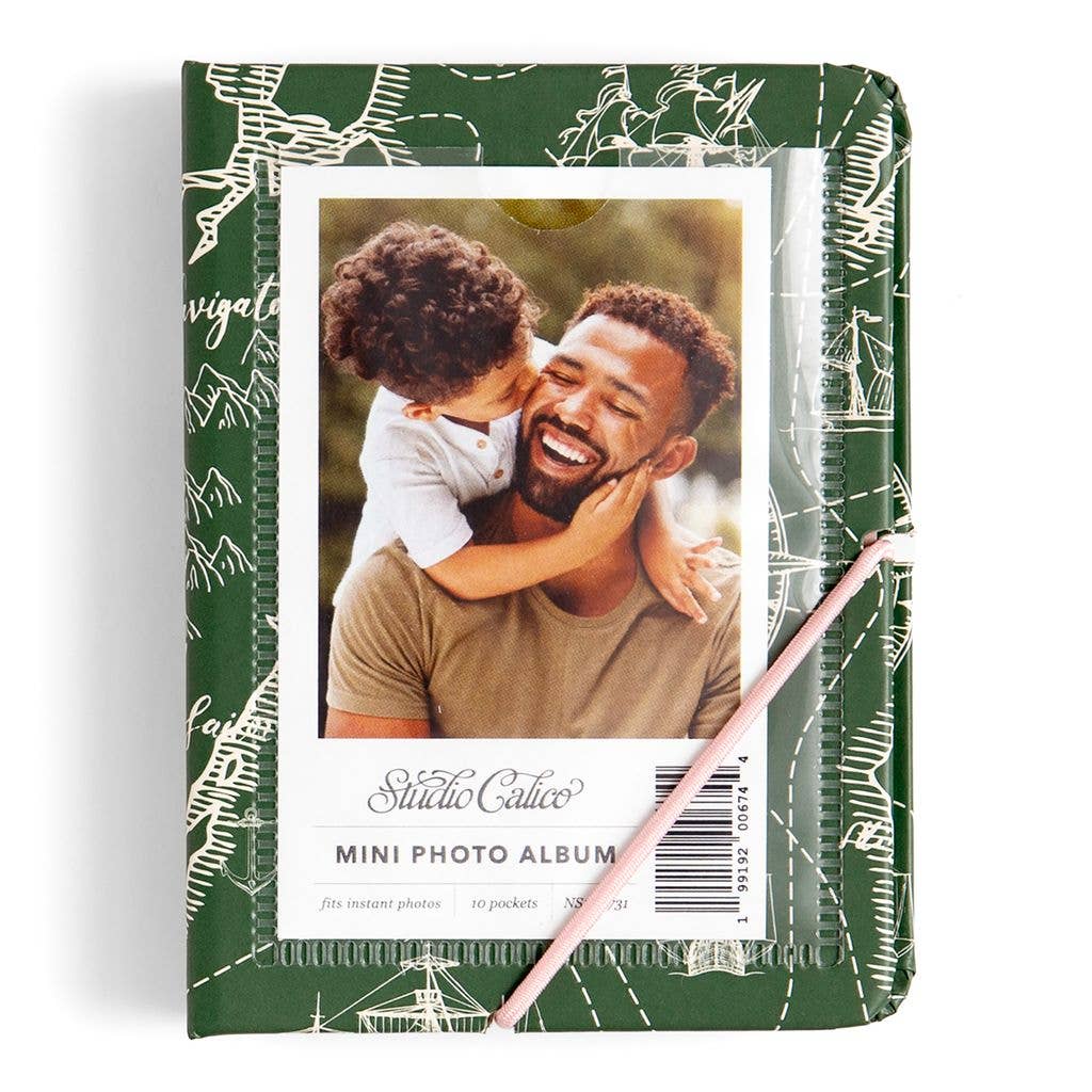 Mini photo album with a green cover featuring a photo of a man and child, and a pink pen.