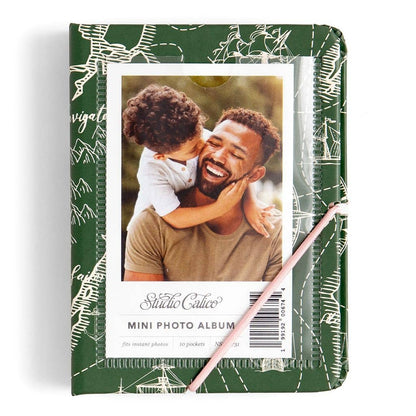 Mini photo album with a green cover featuring a photo of a man and child, and a pink pen.