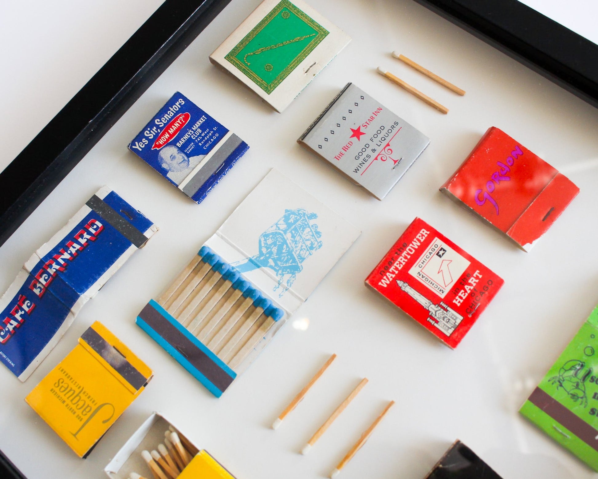 Collection of matchboxes and matches on a white surface