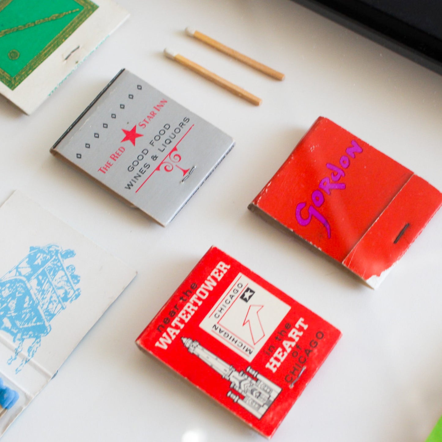 Collection of vintage matchboxes and matches on a white surface