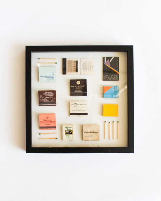 Framed display of various business cards on a white wall