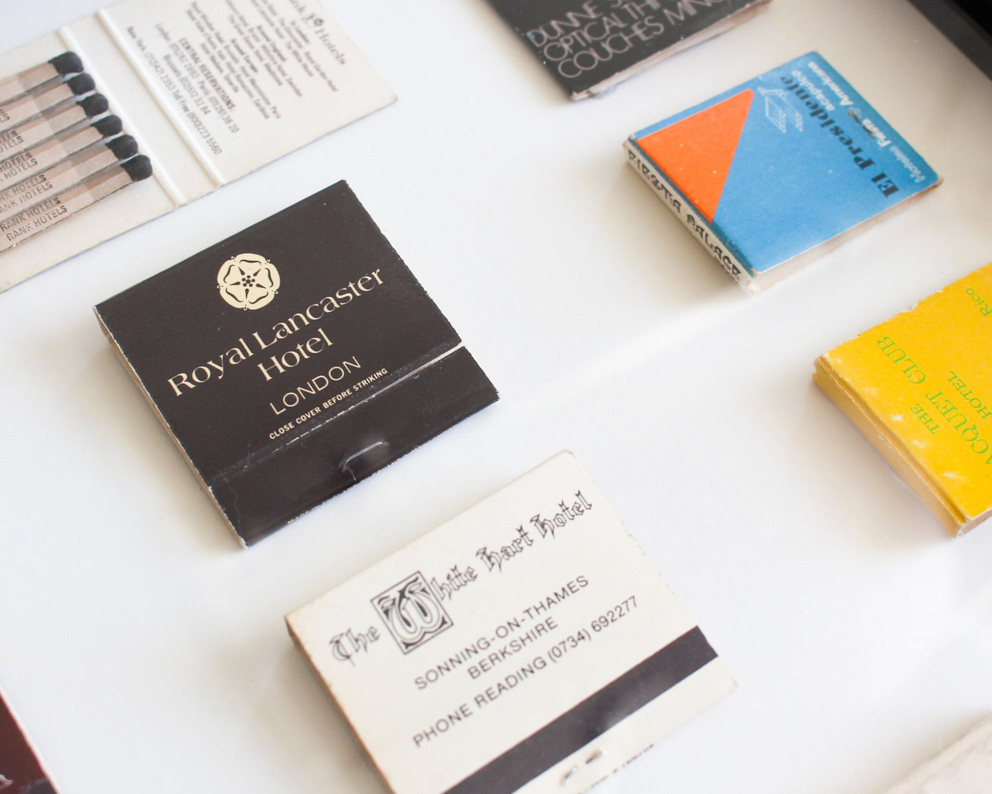 Collection of matchboxes with visible branding on a white surface