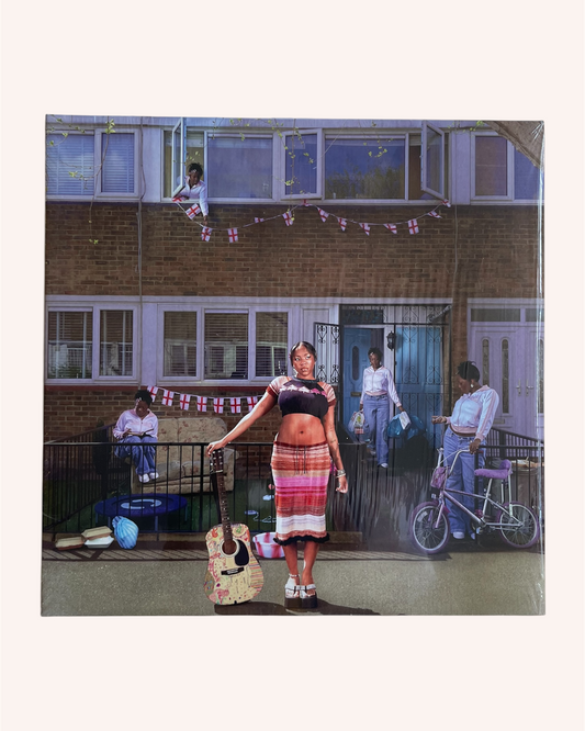 Woman holding a guitar in a residential area with people on balconies. What a Devastating Turn of Events - Rachel Chinouriri
