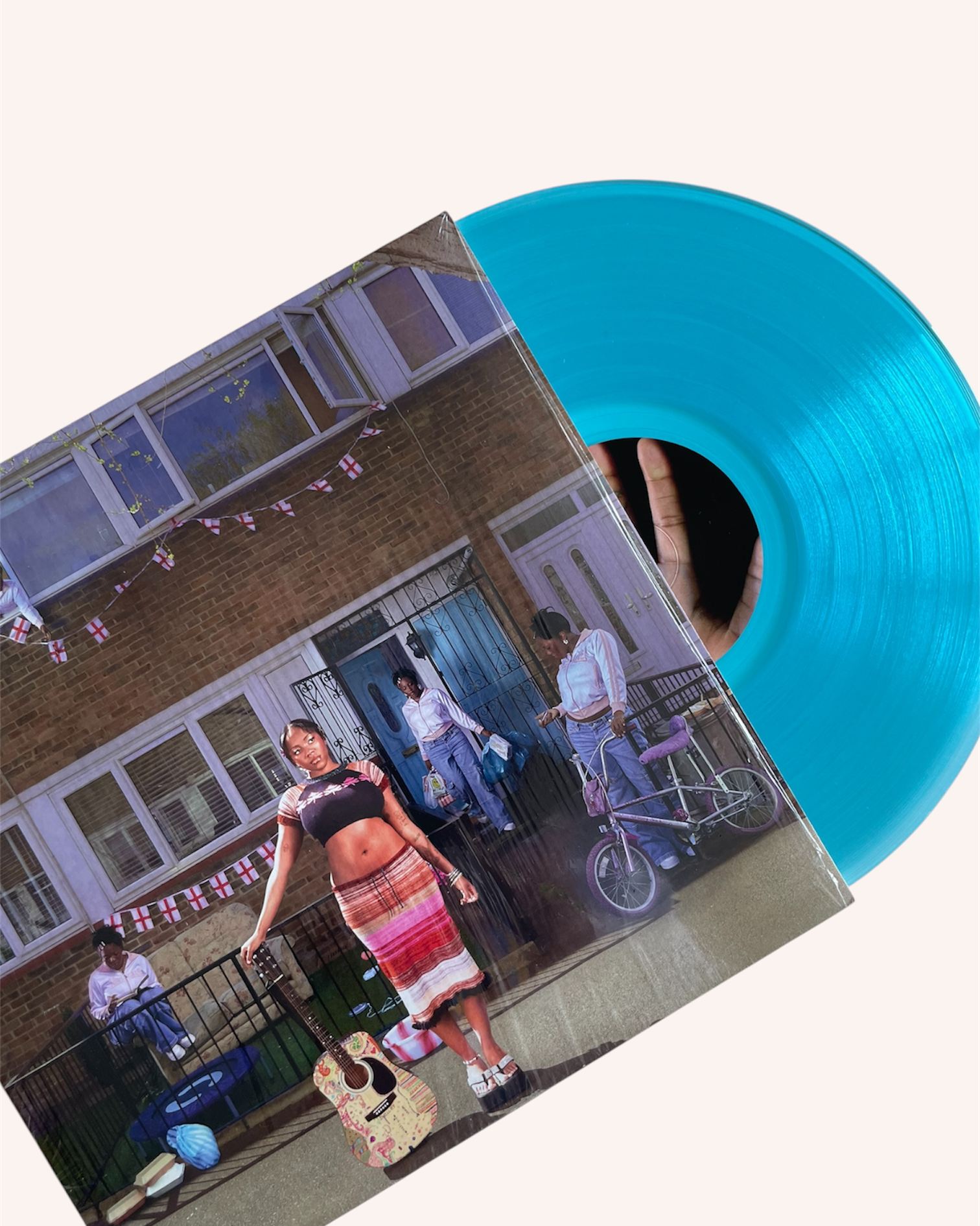 Vinyl record with a colorful cover featuring people on a street scene.