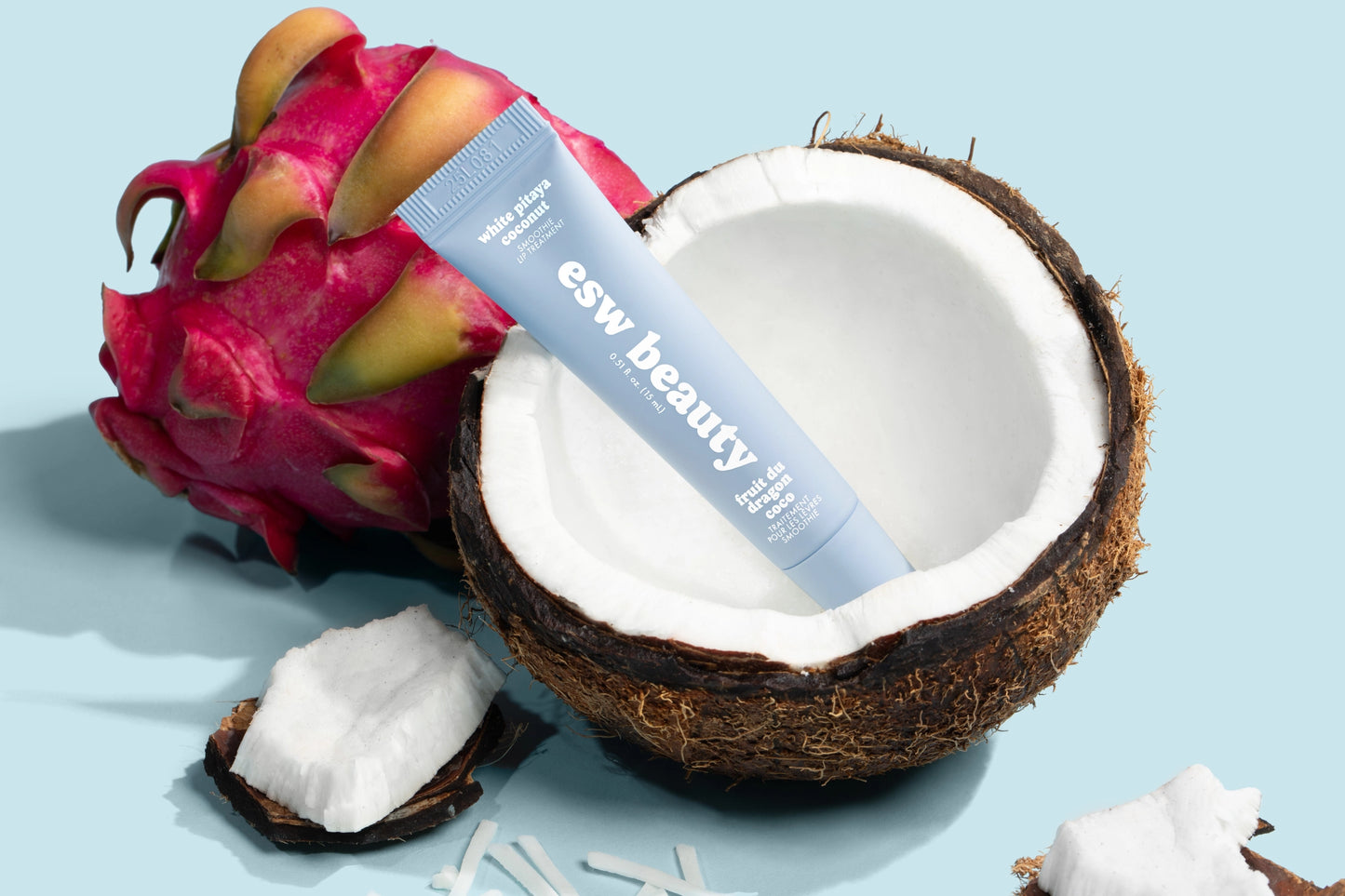 Tube of 'eww beauty' cream with a dragon fruit and coconut on a light blue background