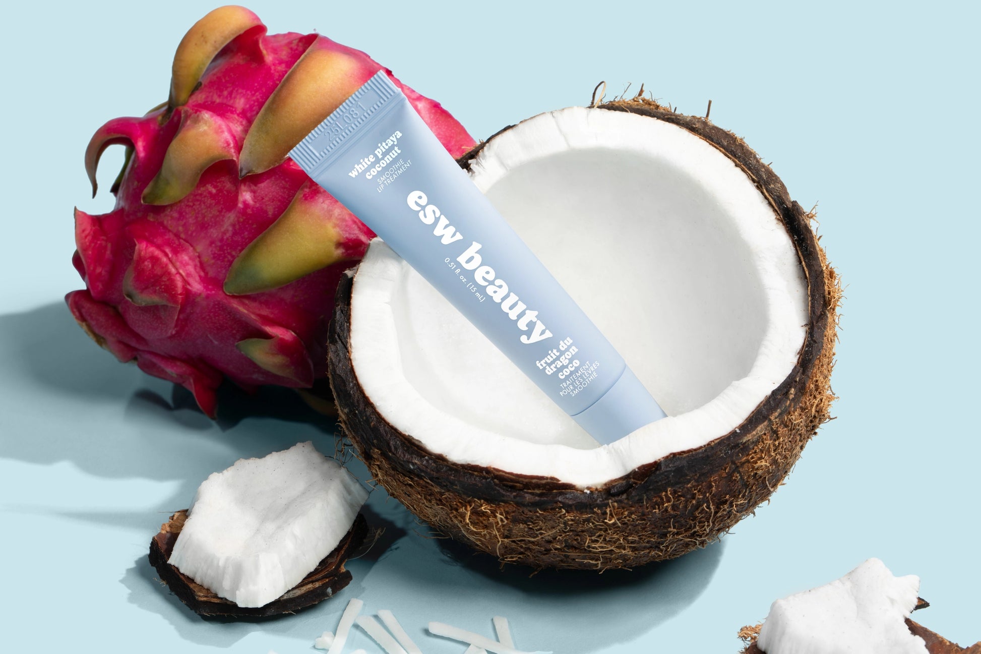 Tube of 'eww beauty' cream with a dragon fruit and coconut on a light blue background