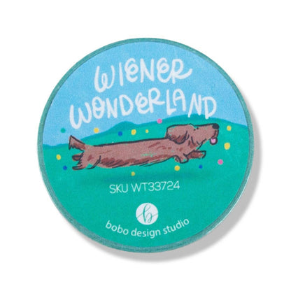 Round product with 'Wiener Wonderland' text and a dog illustration on a blue background, featuring the Bobo Design Studio logo.