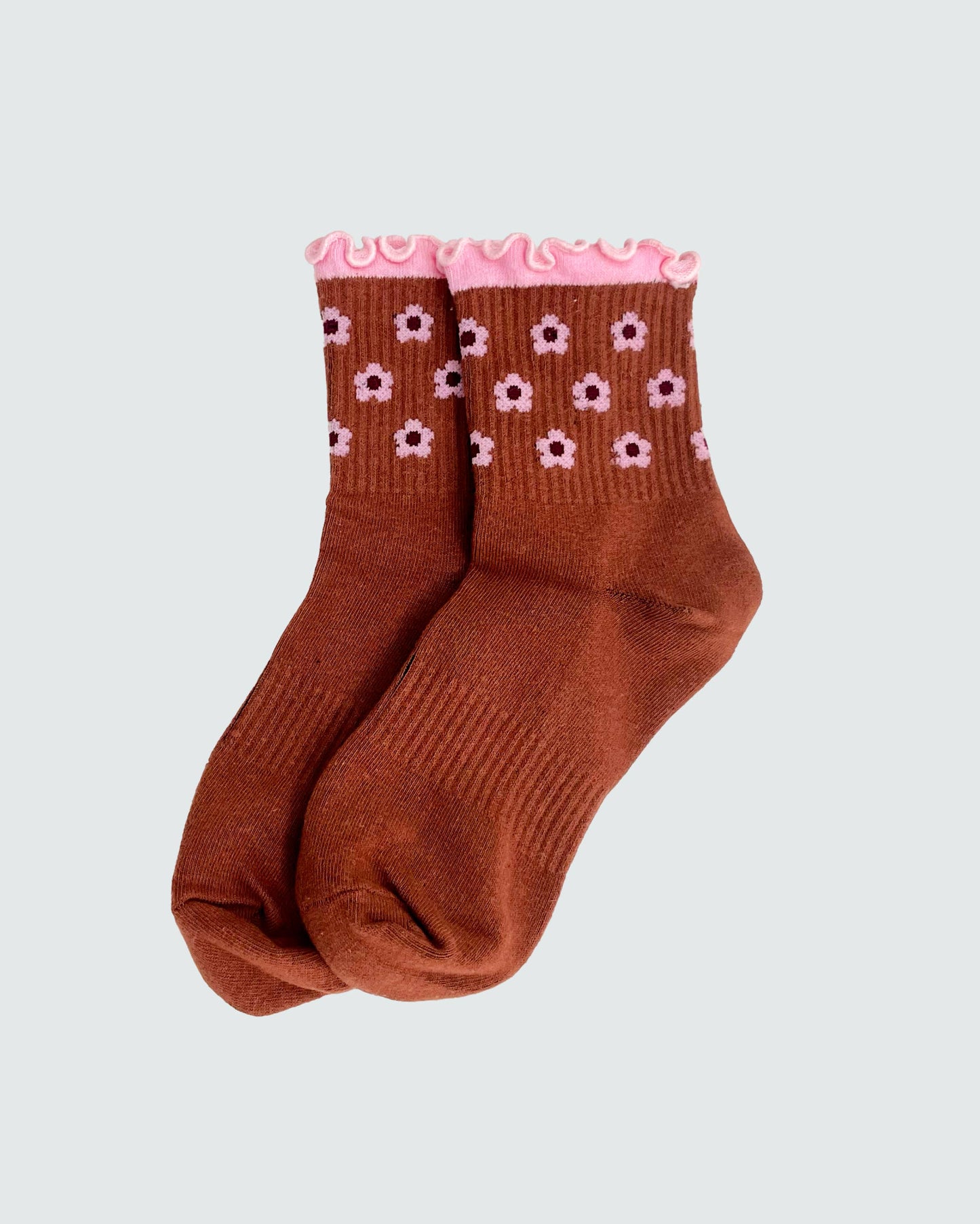 Brown socks with pink flower patterns on a light gray background