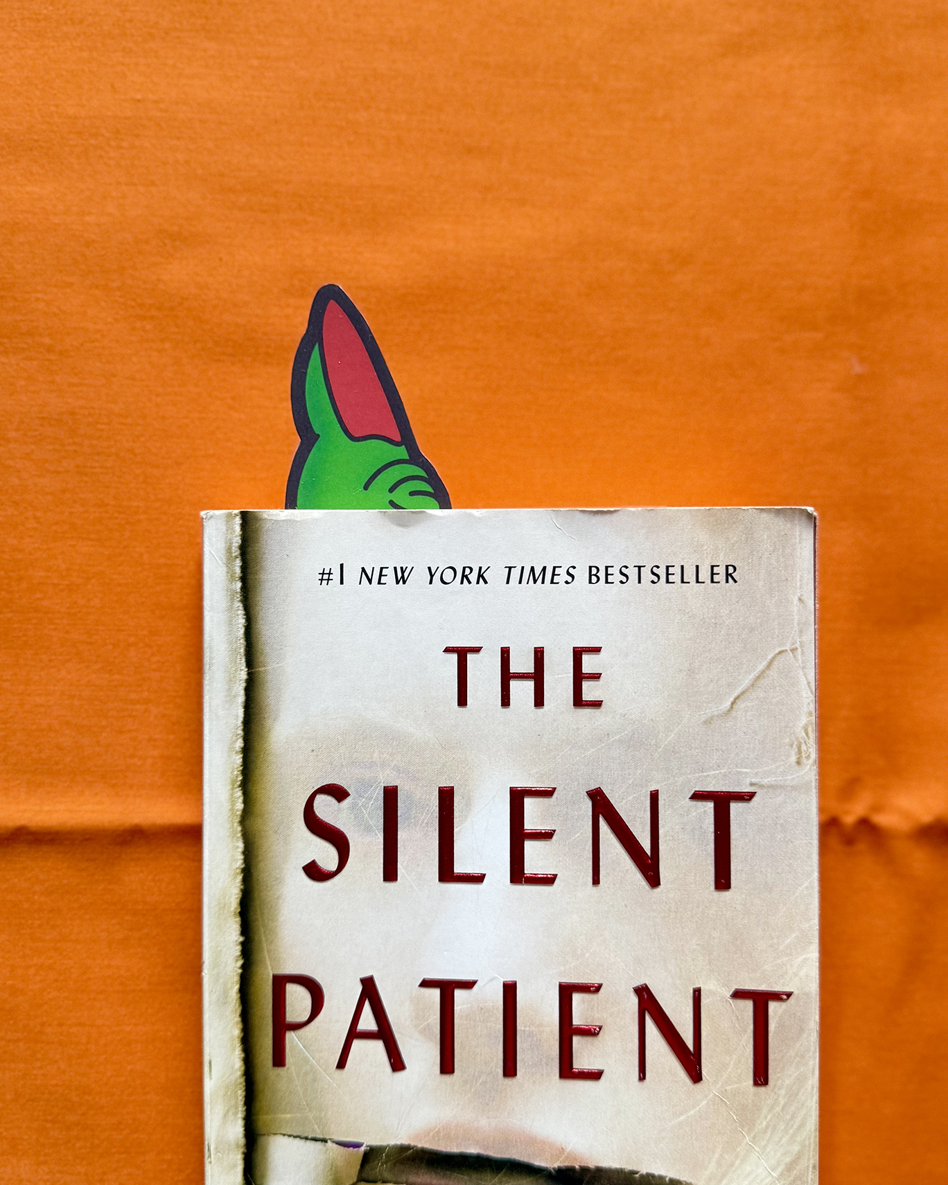 Book titled 'The Silent Patient' by Alex Michaelides on a wooden surface