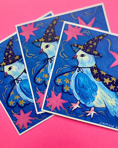 Three overlapping art prints featuring a whimsical blue bird wearing a star-patterned witch hat and cape, set against a bright pink background.